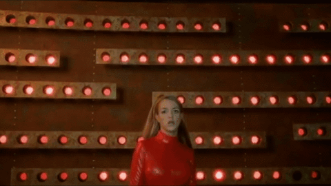 A gif of Britney Spears in her iconic red spandex outfit singing 'Oops I did it again.'